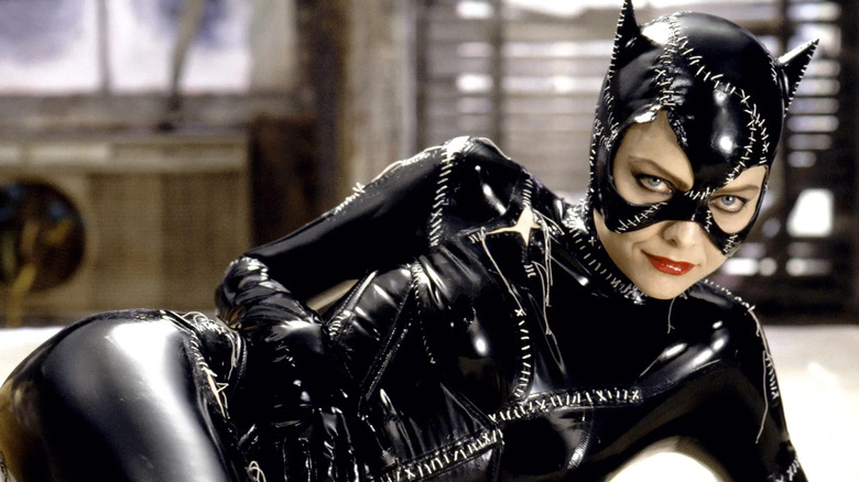 Catwoman dressed in costume and laying on a bed