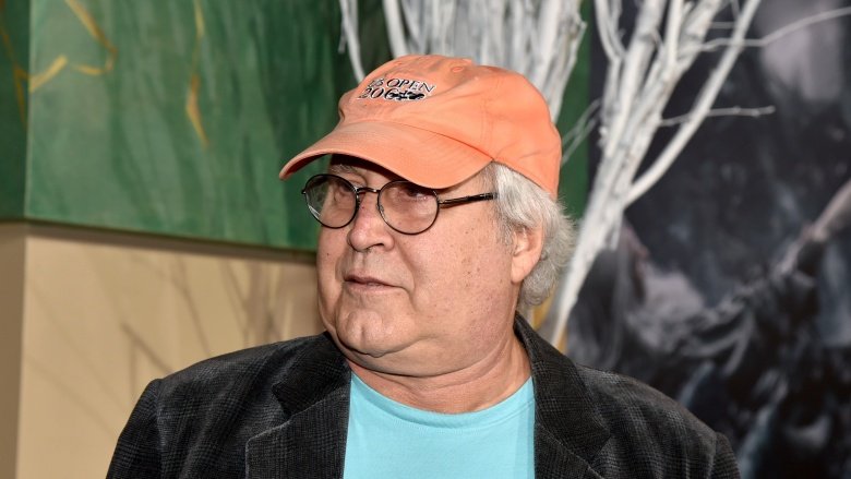 Chevy Chase wearing a peach-colored baseball hat