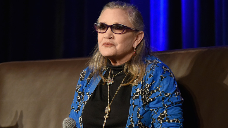 Carrie Fisher sits on stage