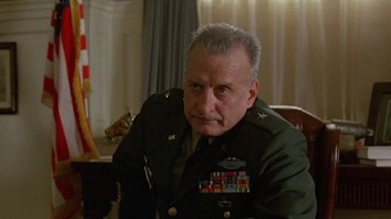 George C. Scott sits in a chair