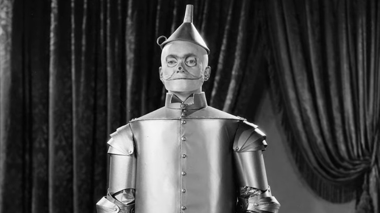 The Tin Man in front of curtains