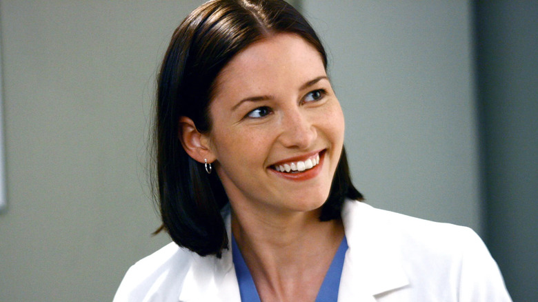 Lexie smiling in doctor scrubs