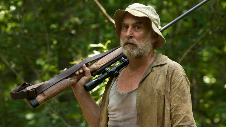 Dale holding rifle in woods