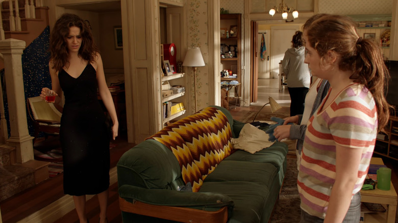 Fiona (Emmy Rossum) holding a drink while Debbie (Emma Kenney) watches on Shameless