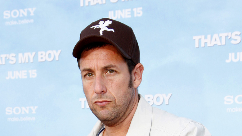 Sandler in baseball cap on red carpet