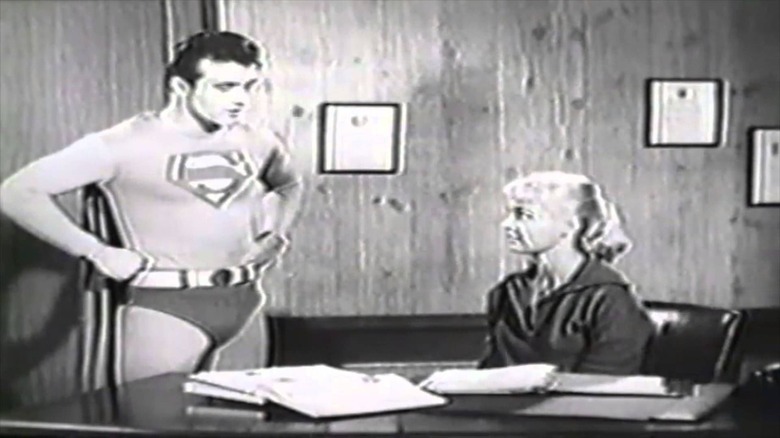 Superboy talks to a girl at a desk