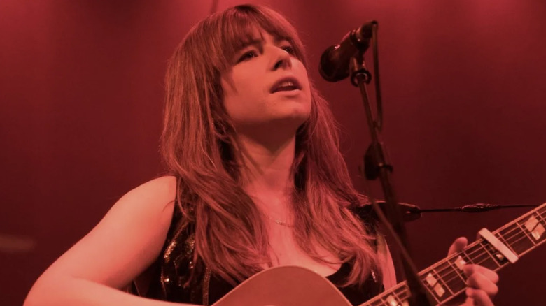 Rose-Lynn Harlan plays guitar onstage in "Wild Rose" (2018)