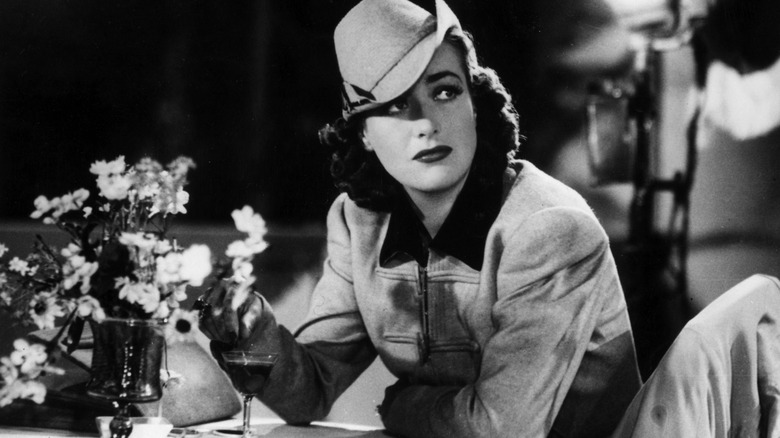 Joan Crawford sitting at a table