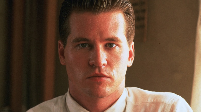 Val Kilmer looks forward in a dress shirt