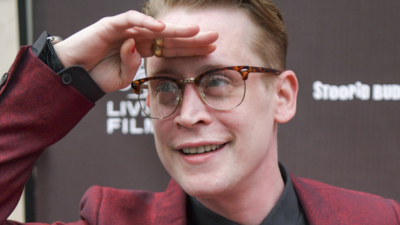 Macaulay Culkin with hand at his forehead