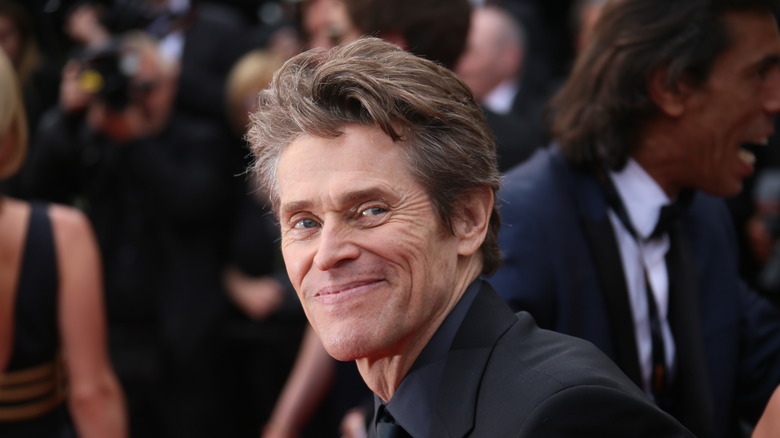 Willem Dafoe smiling for the camera