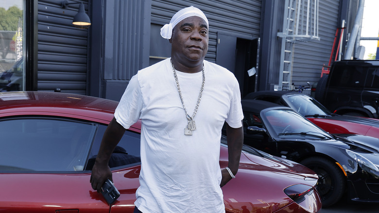 Tracy Morgan leans against a car