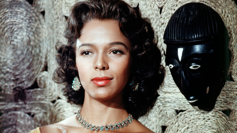 Dorothy Dandridge smiles beside mask