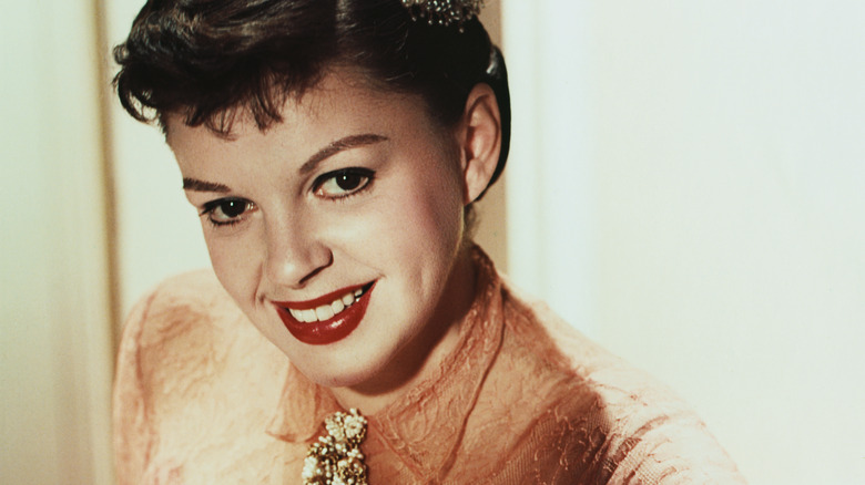 Judy Garland smiles wearing dress