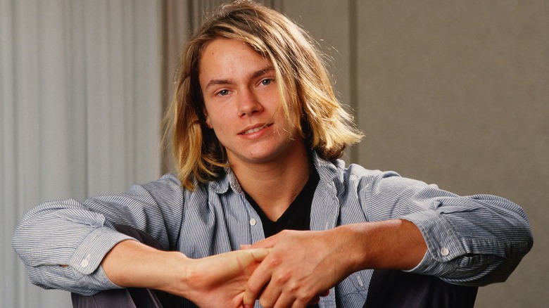 River Phoenix sits and smiles