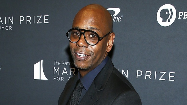 Dave Chappelle wearing black glasses