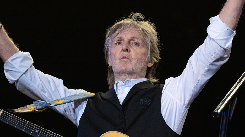 Paul McCartney raises his arms