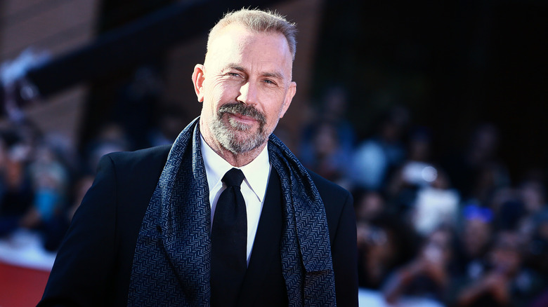 Kevin Costner wearing a scarf on the red carpet