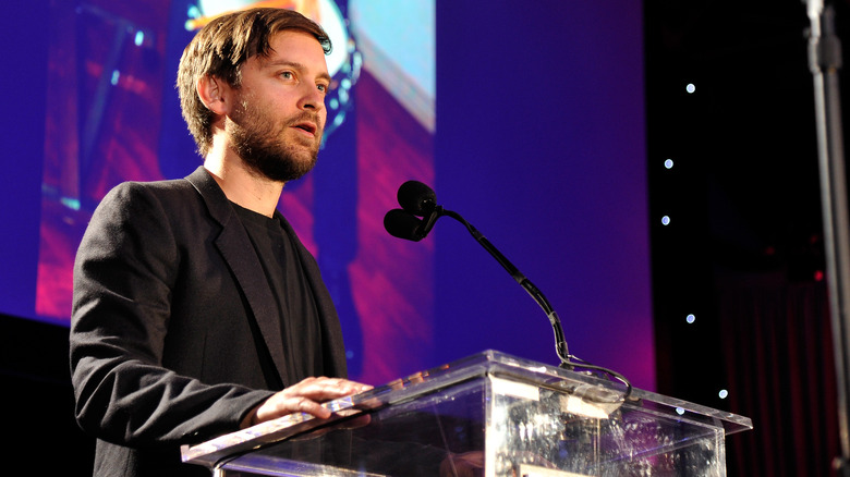 Tobey Maguire speaking at a podium