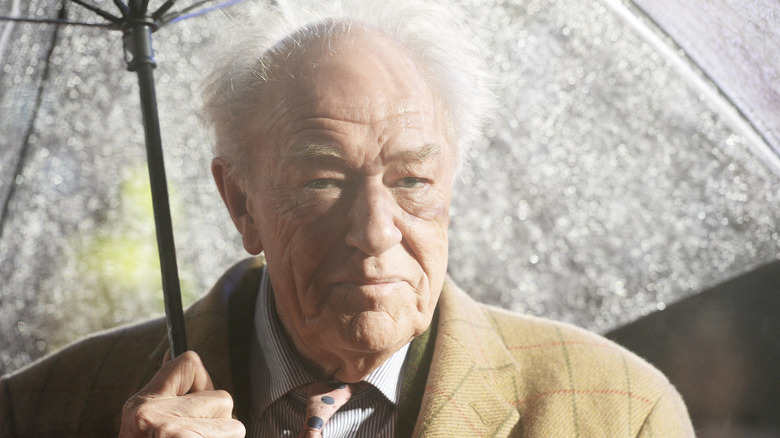 Michael Gambon holding umbrella