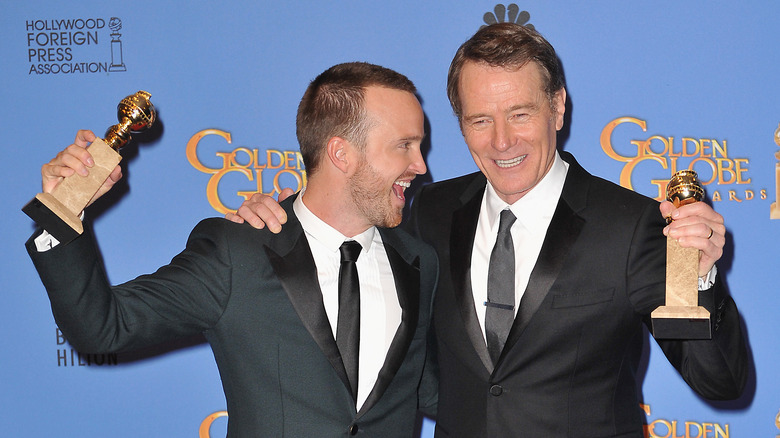 aaron paul and bryan cranston smiling holding awards