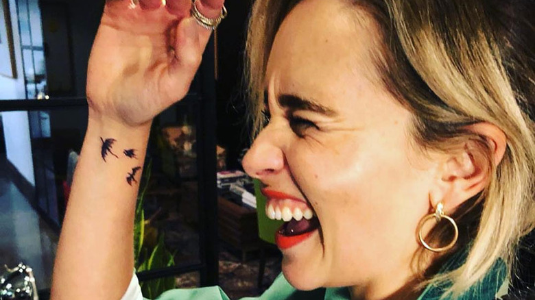 Emilia Clarke laughing with her arm up