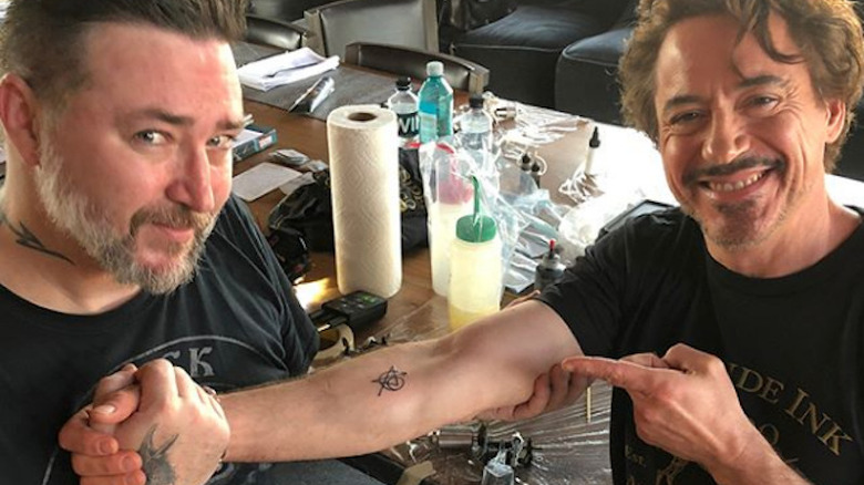 Robert Downey Jr and Joshua Lord showing off Avengers tattoo