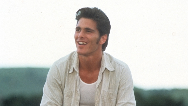 Michael Schoeffling sitting on a fence in Sylvester