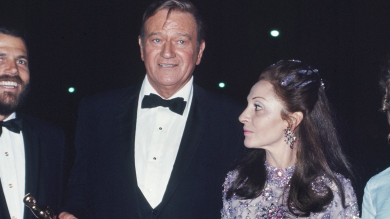 John Wayne poses with his Oscar and wife.