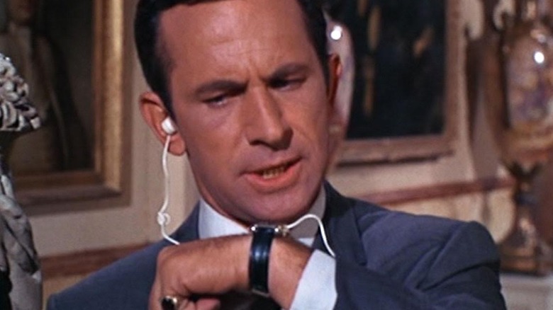 Don Adams speaks into a watch 