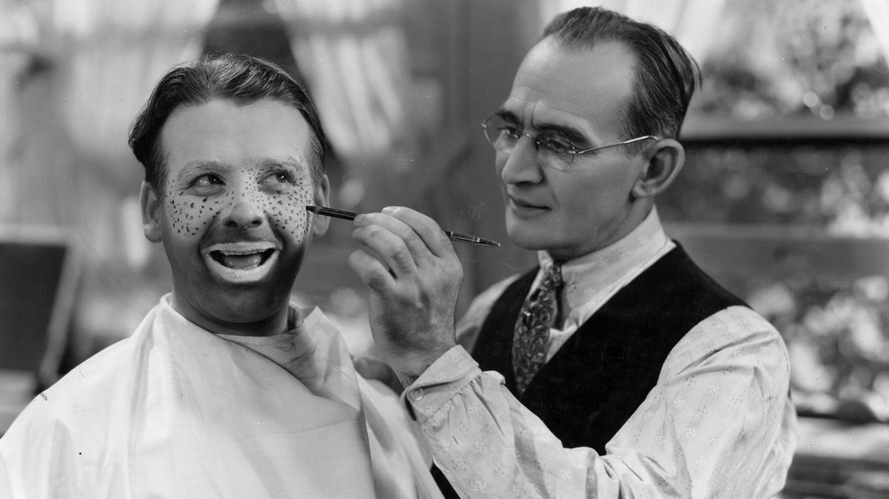 Wallace Ford receiving clown makeup