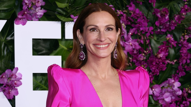 Julia Roberts in front of purple flowers