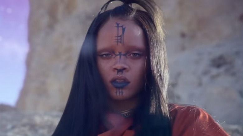 Rihanna dressed as an alien stares at camera