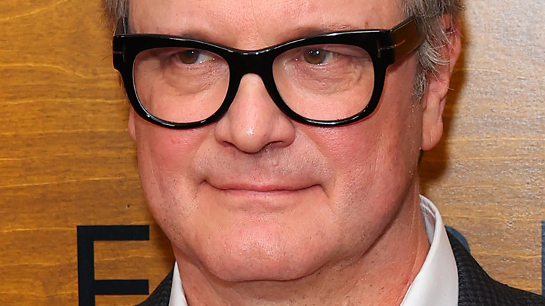 Colin Firth smiling in glasses in 2022