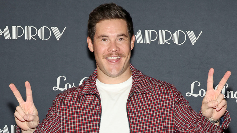 Adam Devine giving peace signs