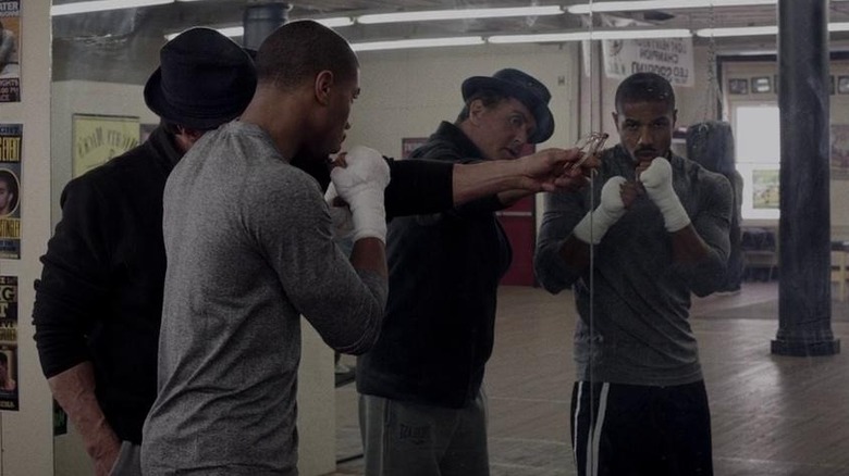 Rocky Balboa and Adonis Creed in mirror in gym