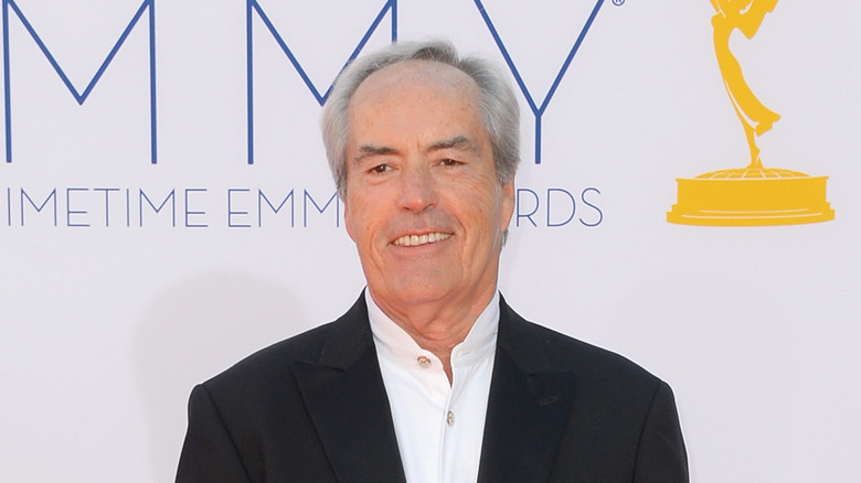 Powers Boothe smiles before an Emmy banner