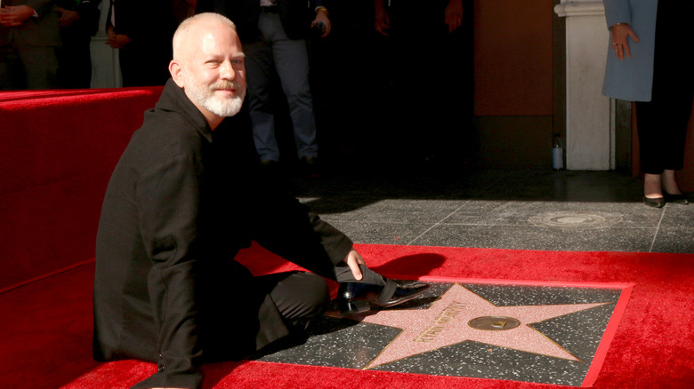 Ryan Murphy sitting by walk of fame star