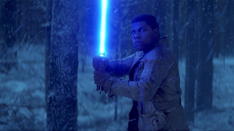 Finn holding blue lightsaber