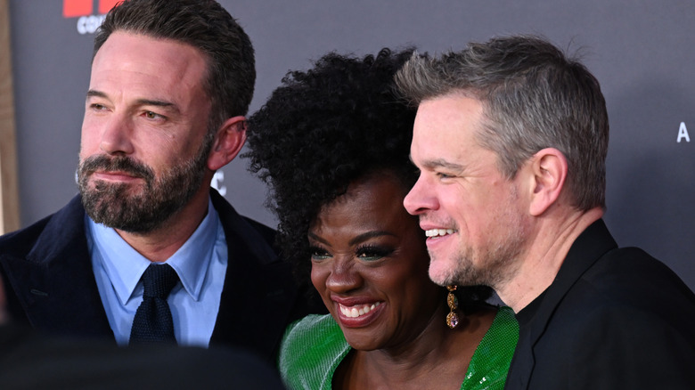 Ben Affleck, Viola Davis, and Matt Damon smiling together on red carpet