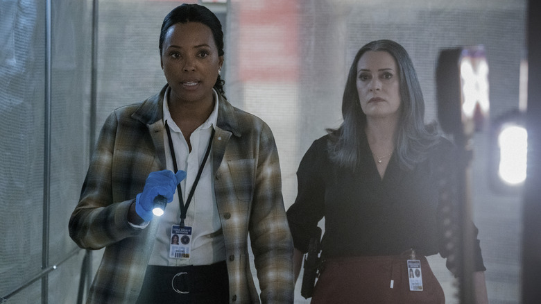 Aisha Tyler as Dr. Tara Lewis holding flashlight and Paget Brewster as Emily Prentiss in Criminal Minds: Evolution