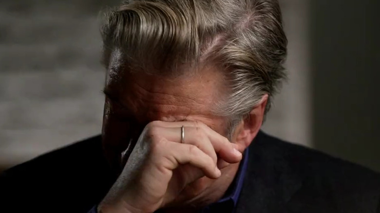 Alec Baldwin wipes away tears in an interview