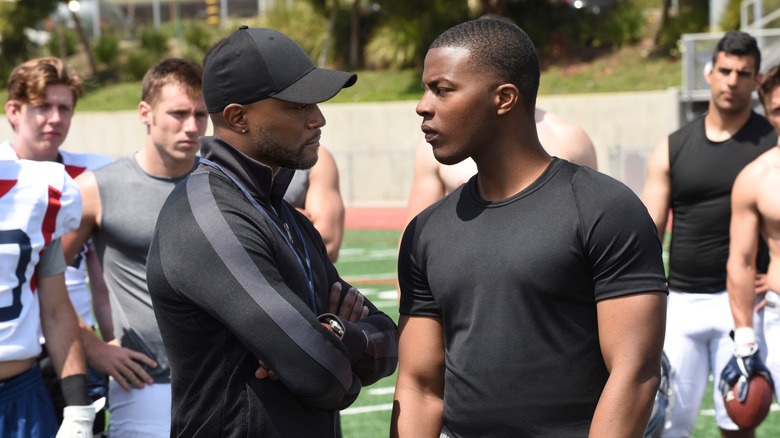 Spencer James on football field with team and coach