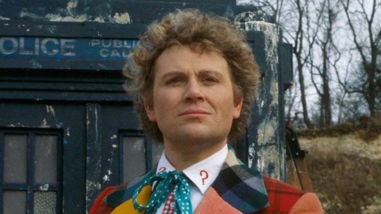 The sixth doctor with the tardis in a forest