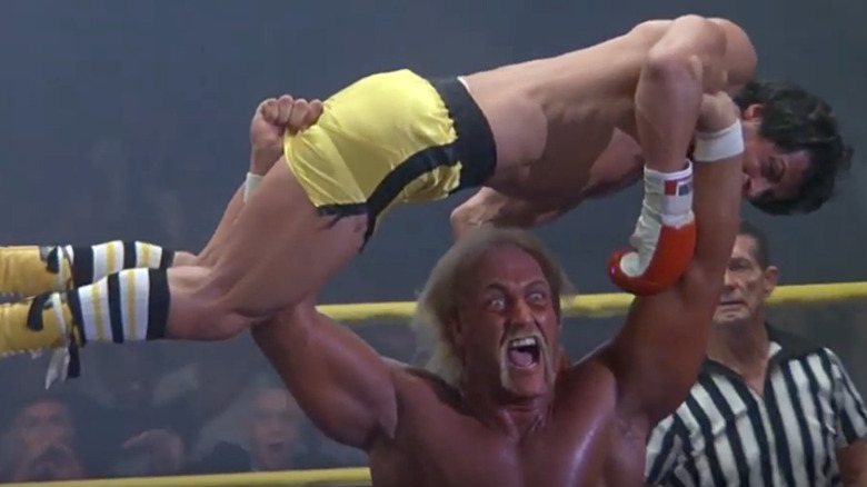 Thunderlips holding Rocky above his head as ref looks on