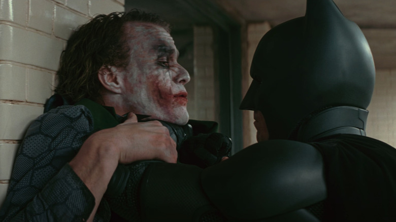 Batman choking Joker against wall