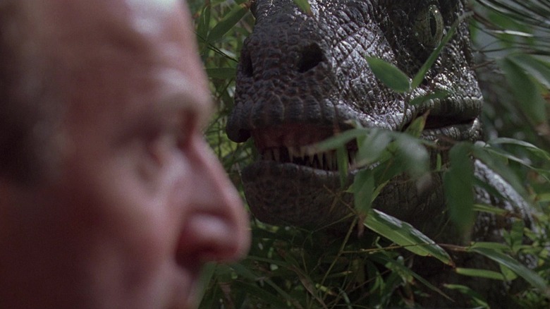 Raptor appears in the grass next to Robert Muldoon