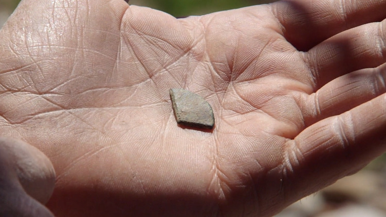 Hand holds cut coin