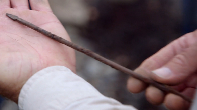 Hands display a Roman pilum