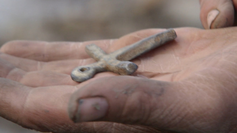 Hand holds a small cross